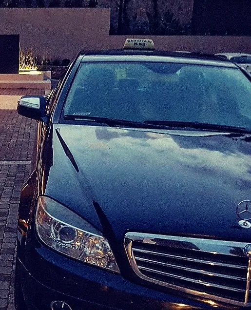 The taxi waiting at a hotel entrance at dusk